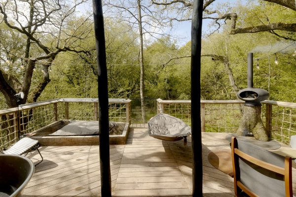 The sun deck of the treehouse with cargo net day bed, hammock and Pizza oven.